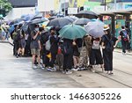Small photo of CAUSEWAY BAY, HONG KONG - JULY 25, 2019: Protesters conceal their identity with umbrellas whilst they unbolt and remove pedestrian barriers in advance of Hong Kong protests.