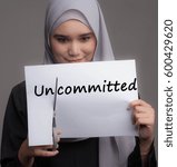 Small photo of A pretty girl cut the word uncommitted . Transformation from negative to positive or bad to good concept.