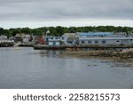 Small photo of Bearskin Neck in Rockport, MA on a partly cloudy summer afternoon. View of water and nature outside of Boston.