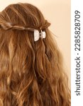 Small photo of Dark blonde hair twisted back and clasped in a claw clip. Pearlescent hair clip. Trendy hairstyle. Boho hairstyle. Healthy, shiny hair.