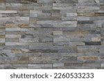 Background with detail and texture of surface with stone cladding in different shades of gray and brown