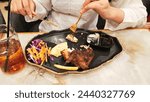 Small photo of portrait of a woman's hand stabbing khubus (pita bread) accompanied by oven-roasted chicken, typical Arabic food with a fork and knife on a plate at a 45 degree angle
