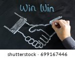 Businessman draw a handshake on chalkboard for win win strategy concept