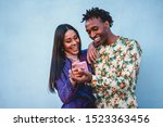 African couple watching videos on smartphone - Young people having fun shopping online with new trend technology - Youth, tech addiction, love and fashion concept - Soft focus on man face