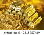 Small photo of Gold bars and gold jewelry on the golden reflect light background. Gold is hard commodity good, risk asset, tangible value that used to be gold reserve,safe assets during war and economic crisis.