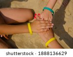 Small photo of Family wearing color entrance wristbands of hotel resort or entertainment park at sand sea background.