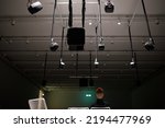 Young man listening to sound music surround installation with many speakers above