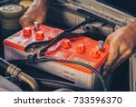 A car mechanic replaces a battery
