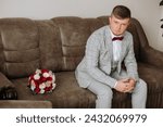 Small photo of groom with a bouquet of roses, groom with bouquet, groom with a wedding bouquet, a young man with a wedding bouquet on his hand, well suited man