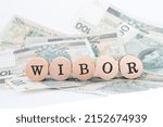 Small photo of Gdynia, Poland - 2022-05-04 Word wibor written in polish with wooden blocks standing on money, "wibor" is a shortcut for Warsaw Interbank Offered Rate