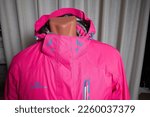 Small photo of Kirov, Russia - January 16, 2023: Pink beautiful ski jacket photographed for sale in a private room, in an atelier or store. Inept shooting of clothes for sale