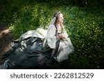 Small photo of Beautiful seductive dryad. Pagan spirit of the forest. Portrait of beautiful dryad. Fairy who loves nature in beautiful green summer forest. Concept of environmental friendliness and caring for nature