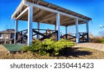 Small photo of Beautiful Wooden gazebo outdoor on Sunny autumn or spring day with blue sky. Early sprint time and pavilion or alcove in village or small town on nature landscape