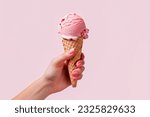 female Hand holding strawberry ice cream cone