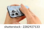 Small photo of Black smart phone with broken display isolated on white background. Mobile smartphone with broken screen isolated on white background and broken camera.