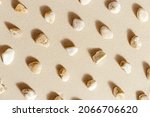 Sea stones neutral beige color on natural fine sand background. Styled pattern from natural white yellow pebbles, monochrome tones. Spa minimal background, concept for meditation and relax, flat lay