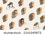 Small photo of Creative pattern with champagne cork on beige background with hard light and shadows at sunlight. Minimal summer layout with bottle cap from sparkling wine and metal wire muselet, top view, flat lay