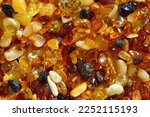 Natural gemstone amber texture background, small stones yellow orange gradient color. Natural mineral material for jewelry. Top view Amber texture. Aesthetic sunstones wallpaper, pieces ancient resin.