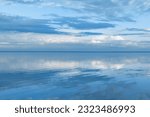 Beautiful white blue clouds over lake, symmetric sky background, cloudscape on lake Ik, Russia. Nature abstract, cloudy sky reflected on water, calm windless weather, natural environment, skyline