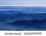 Small photo of Winter nature panorama of far away blue mountains, picturesque view, aerial tonal perspective, monochrome photo of range mountains and blue sky, hills covered forest, great landscape in Altai, Russia