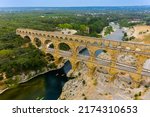 Small photo of Three-tiered aqueduct Pont du Gard. Roman aqueduct, Pont du Gard, Languedoc-Roussillon France, aerial view. Aerial photo of Pont du Gard is ancient Roman aqueduct that crosses the Gardon River.