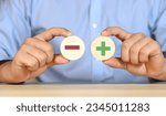 Small photo of Wooden blocks showing plus and minus signs. The concept of antithesis. Decision making. Positive or negative business choice. Analysis of advantages and disadvantages Comparison