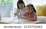 Small photo of Little cute girl play and learn offline class computer language game Unplugged Coding computing concept with mom for asia kindergarten gen Z smart kids sit at table home sofa. STEM STEAM ICT skill.