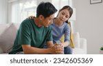 Small photo of Asia young people stress relief trust talk share suffer cancer pain sick family loss bad news crisis. Sorrow cry man and carer woman sit at sofa home help listen by love hold hand warm hug touch wife.
