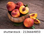 Small photo of Fresh Yellow Peach fruit in wooden bowl on wooden background, Yellow Peach with slice in wooden basket.