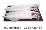 Small photo of Fresh Squid isolated on white background, Fresh Splendid Squid on black plate With clipping path.