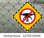 No drone zone Warning sign at fence wall, Prohibition sign to fly with drones on the net fence. No drone zone, No drone flying at perimeter fence netting of airport airspace or Detention Center