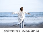 Woman taking deep breaths and stretching on sandy beach Stress free