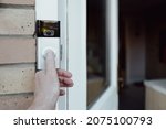 Small photo of London, UK - Circa November 2021: Shallow focus of a homeowner seen testing a newly installed WiFi smart doorbell. to hear the installed wireless indoor ring speaker activate.