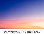 Colorful sunset sky in the evening on twilight with peaceful orange sunlight and blue sky background.