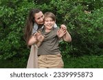 Small photo of Mother and son sharing an unposed, heartwarming moment in a park, exemplifying the appeal of candid photography