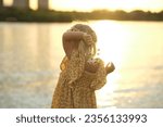Small photo of heartfelt smile of girl holding daisies, set against simple park background, advocates for a return to simpler, less materialistic values. benefits of a minimalist lifestyle or simple living.