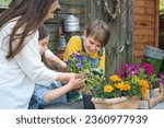 Small photo of mother and her children revel in the simple joys of gardening, sowing seeds in soil and love in their hearts, under the sun's nurturing gaze.