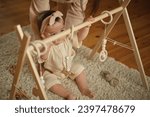 Small photo of With focused eyes, a baby interacts with eco-friendly toys, grasping at nature's shapes. Reflects a growing awareness and motor skills.