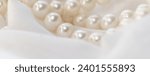 Small photo of A string of pearls nestles softly on a light fabric, their subtle glow embodying elegance. It's a gentle nudge towards appreciating the enduring charm of natural beauty.