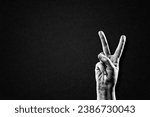 Hand Showing Peace Victory Sign in Black and White on Textured Paper Background, Copy Space