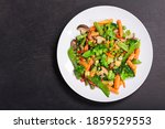 plate of stir fried vegetables on dark background, top view