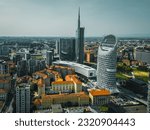 Small photo of Milan, Italy - 18.06.2023: Aerial view of Milan Porta Nuova district, city skyline, Gae Aulenti and skyscraper of Unicredit Tower, Bosco Verticale in Lombardy in the background.