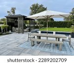Small photo of Gorgeous outdoor living backyard patio with pergola, outdoor rug, tequila bar, dining set, couch, television, pool with waterfall , fire pit and stunning Techo Bloc patio pavers - Inspired by tulum.