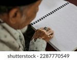 Small photo of A blind person reads the braille Quran during Ramadan in North Sumatra, Thursday, March 30, 2023.