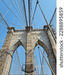 Small photo of From the pedestrian zone of the Brooklyn Bridge, the view is simply breathtaking! You can't help but feel awestruck by the enormous stone pillars holding up the bridge's structure and the steel cables