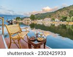 Small photo of Srinagar, Jammu and Kashmir, India, 20th July 2021, Image of the sunset at the Dal Lake with Cup of Kahwah and Kashmiri biscuits on the porch of houseboat