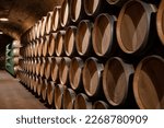 Small photo of Old french oak wooden barrels in underground cellars for wine aging process, wine making in La Rioja region, Spain