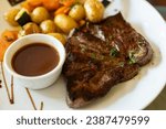 Dish in old bistro in Limoges, France, Limousin cattle beef steak served with oven baked potatos, served with light broth or gravy