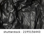 Crumpled garbage bag texture background. Trash package pattern, wadded up plastic bin bags, black polyethylene waste container