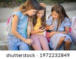 Childhood in the digital age. Three little girls playing outside.